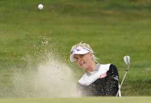 woman golf bunker stroke