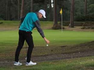 man dropping golf ball