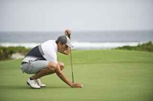 Marking golf ball on putting green